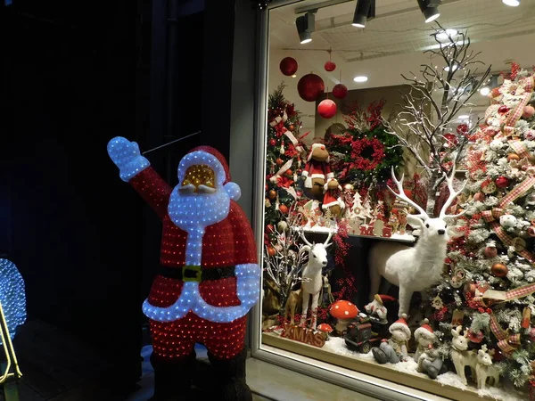 Mağaza vitrininde büyük bir Noel Baba ve Noel süslemesi.