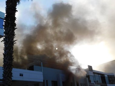 1 Ekim 2020, Glyfada, Atina, Yunanistan. Yanan bir dükkandan çıkan duman güneşi gizliyor.