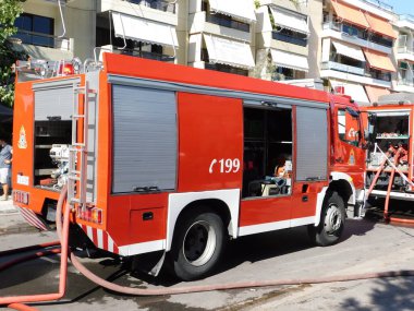 1 Ekim 2020, Glyfada, Atina, Yunanistan. Bir itfaiye kamyonu iş başında, yanan bir dükkanın yanında.