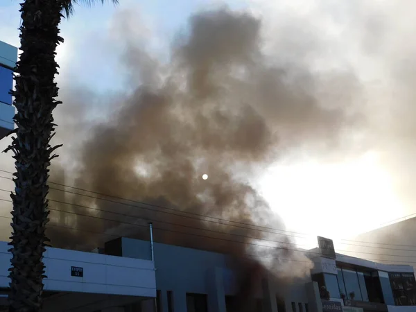 1 Ekim 2020, Glyfada, Atina, Yunanistan. Yanan bir dükkandan çıkan duman güneşi gizliyor.