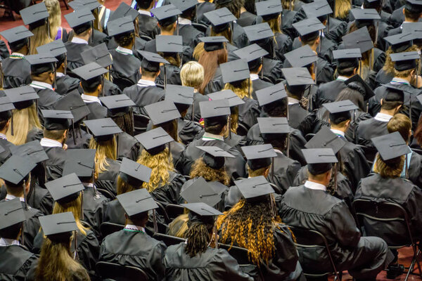 crowd of graduates standing at ceremony