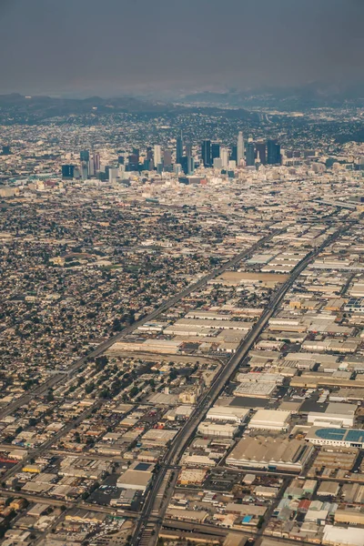 飛行機と煙からロサンゼルスのダウンタウンのスカイラインと郊外 — ストック写真