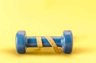 santimetre sarı bir arka plan üzerinde halterle Sarı santimetre/mavi mavi halterle. Kopya alanı