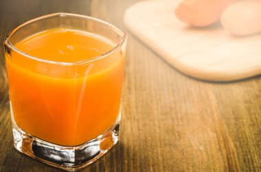 taze havuç suyu bir ahşap arka plan üzerinde hazır gözlük / taze havuç suyu bir ahşap arka plan üzerinde hazır gözlük. Tonda. kopya alanı