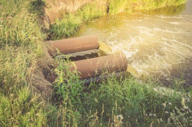 kanalizasyon dan kanalizasyon bir göl kirletiyor / Atık su borusu göle gün doğumunda