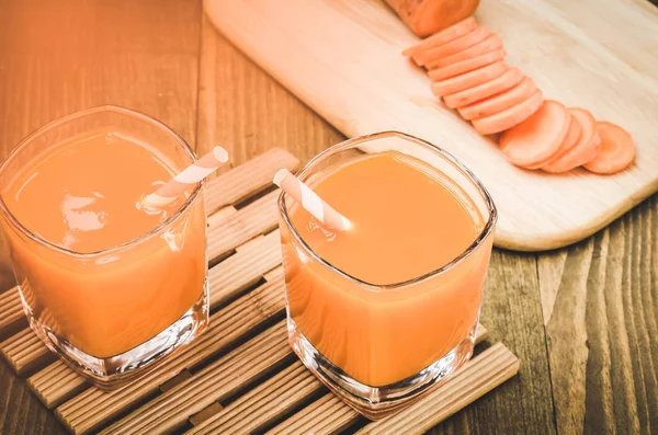 Get ready for two glasses drinking Carrot/Get ready for two glasses drinking Carrot on a wooden background. Toned