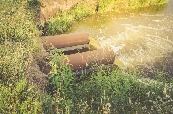 kanalizasyon dan kanalizasyon bir göl kirletiyor / Atık su borusu göle gün doğumunda