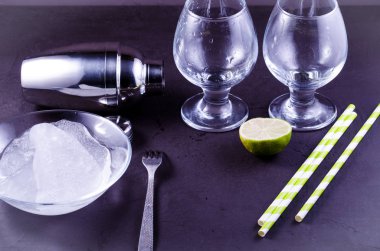 Kokteyl shaker, iki kireç ve payet/kokteyl shaker, iki cam kireç ve payet karanlık bir arka plan üzerinde cam. Tonda