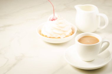 Kahve molası ile taze kek kiraz ve süt/kahve taze kek kiraz ve gri bir arka plan üzerinde süt ile bölünürler. Seçici odak ve boşaltmak