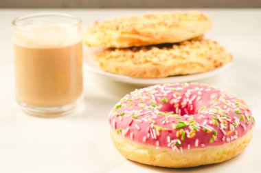 Kahve molası ile taze şekerli çörek ve taze şekerli çörek ve beyaz zemin üzerine kuru bisküvi ile Kuru bisküvi/kahve molası. Seçici odak