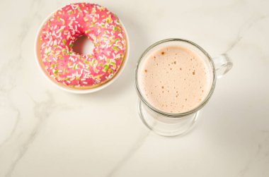 Kahve molası ile taze şekerli pembe çörek üzerinde beyaz mermer zemin ile taze şekerli pembe çörek/kahve molası. Üstten görünüm ve boşaltmak