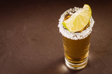 Tekila ile limon meyve/tekila karanlık bir arka plan üzerinde limon meyve ile vurdu vurdu. Üstten görünüm ve boşaltmak