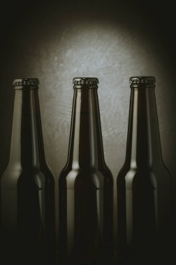 üç şişe bira karanlık bir arka plan üzerine siyah ışık/üç şişe bira ışık ile karanlık bir arka plan üzerinde ile siyah. Seçici odak