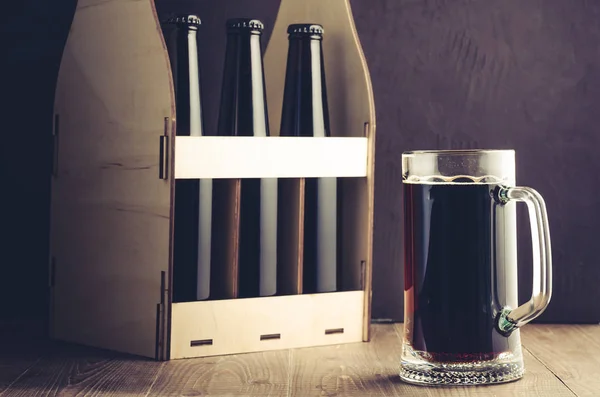 beer bottles case and mug on a dark background/beer bottles case and mug on a dark background. Selective focus