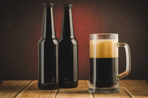 Beer mug and bottles on wooden shelf/Beer mug and bottles on wooden shelf on a red background