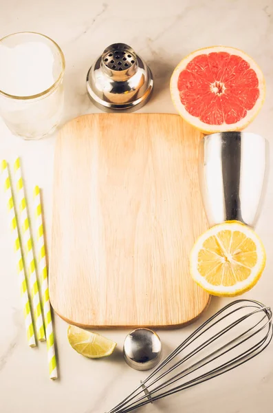 Cocktail shaker and tropical fruits on a white marble background./Cocktail shaker and tropical fruits on a white marble background. Copy space