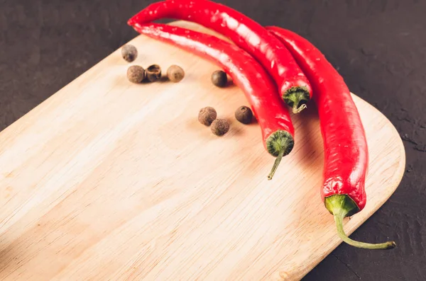 Red hot chili peppers and spices on a empty cutting board/Red hot chili peppers and spices on a empty cutting board. Copy space