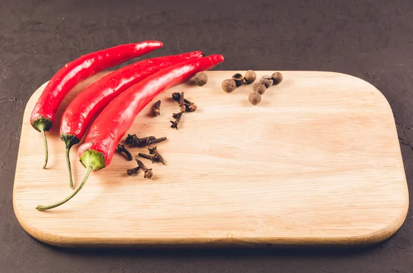 Red hot chili peppers and spices/Red hot chili peppers and spices on a empty cutting board. Copy space