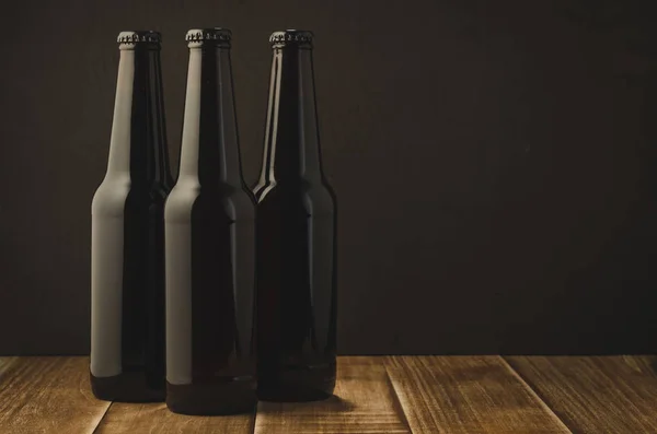 Three bottle of beer on a dark background/Three bottle of beer on a dark background, selective focus and copyspac