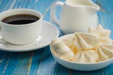 kahve beyaz Kupası ve beze/kahve beyaz Kupası ve mavi bir arka plan üzerinde beze