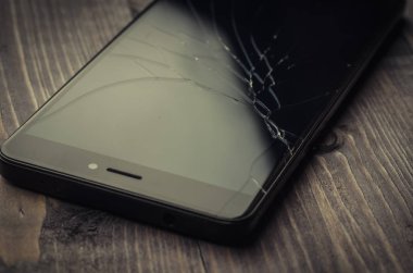 kırılmış cam üzerinde siyah smartphone/kırık camlar ahşap arka plan üzerinde siyah Smartphone