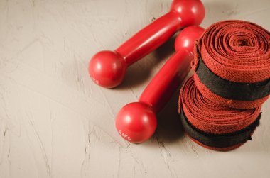 Kırmızı dumbell ve bandaj/spor kavramı kırmızı dumbell ve bir taş bandaj ile. Seçici odak ve boşaltmak