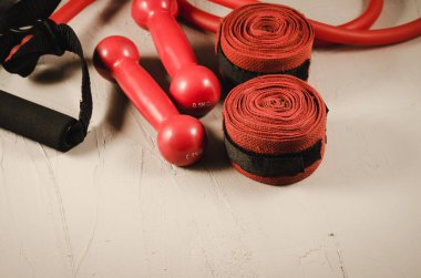 Kırmızı dambıl, bandaj ve ip atlama/sağlıklı kavramı kırmızı dambıl, bandaj ve karanlık bir arka plan üzerinde ip atlama. Seçici odak