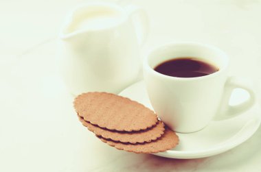 Kurabiye ve süt/kahve beyaz fincan kurabiye ve süt beyaz mermer zemin üzerine beyaz kahve Kupası. Seçici odak ve boşaltmak