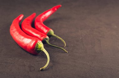 acı biber/kırmızı sıcak Şili Biber karanlık bir taş zemin üzerine bileşimi. Seçici odak ve boşaltmak