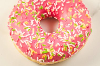 Tatlı ve renkli pembe çörek/tatlı ve bir arka plan üzerinde renkli pembe çörek. Üstten görünüm