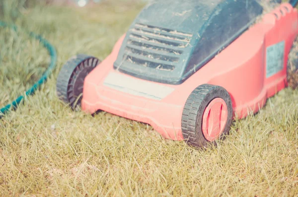 tonsured lawn and the red lawn mower/red Lawn mower cutting green grass