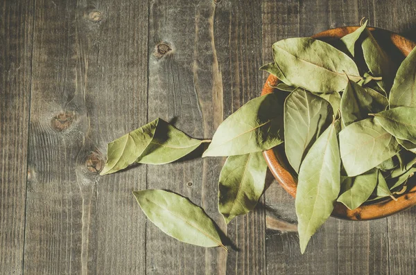 bay leaf in a wooden bowl/bay leaf on a wooden surface dark wooden background. Top view