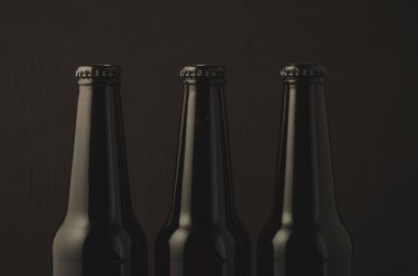 siyah şişe bira karanlık bir arka plan üzerinde koyu arka plan/siyah şişe bira. Seçici odak