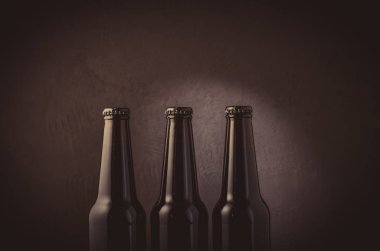 üç şişe bira karanlık bir arka plan üzerinde siyah / üç şişe bira ışık ile karanlık bir arka plan üzerinde siyah. Seçici odak