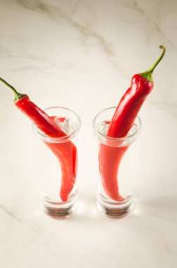 Votka ve votka ve kırmızı biber biber beyaz zemin üzerine kırmızı biber biber/iki çekim. 
