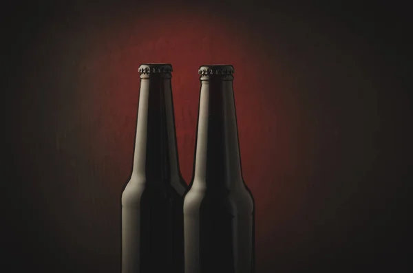 Two bottles of beer/Two bottles of beer on a red background. Copy space