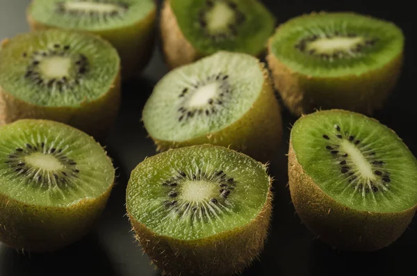 a lot of cut fresh kiwis on a wooden background/a lot of cut fresh kiwis on a wooden background. Top view