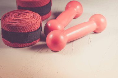 Kırmızı dumbell ve bandaj/kırmızı dumbell ve taş zemin üzerine bandaj.