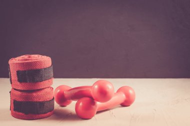 Kırmızı dumbell ve bandaj/kırmızı dumbell ve siyah bir zemin üzerine bandaj. Boşaltmak