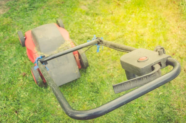 red lawn mower on a green lawn/red lawn mower on a green lawn. Top view