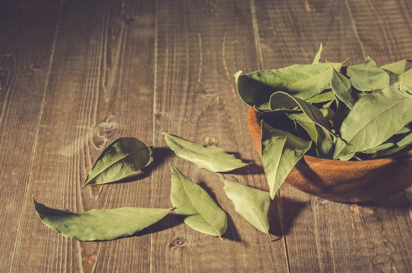 bay leaf in a wooden plate/spices of bay leaf in rural style on a wooden background. Toned