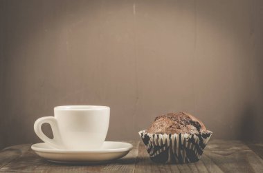kahve fincanı ve bir fincan çikolatalı muffin/kahve ve çikolata kek karanlık bir arka plan, seçici odak üzerinde