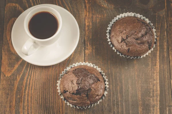 Kaffeetasse Und Zwei Schokoladenmuffins Kaffeebecher Und Zwei Schokoladenmuffins Auf Holzgrund — Stockfoto