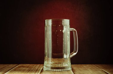 boş bir bardak bira bir kırmızı ışık üzerinde arka plan/boş bir bardak bira ahşap bir masa ve kırmızı bir arka plan, seçici odak