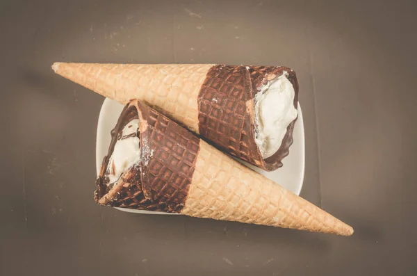 two ice cream with cone in chocolate on a dark background/two ice cream with cone in chocolate, top view