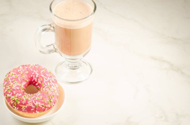 Kahve molası ile taze şekerli pembe çörek üzerinde beyaz mermer zemin ile taze şekerli pembe çörek/kahve molası. Seçici odak ve boşaltmak