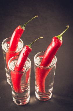 Votka ve votka ve karanlık bir arka plan üzerinde kırmızı biber kırmızı biber/çekim çekim. İçki seti