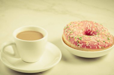 beyaz fincan kahve taze şekerli pembe çörek/beyaz fincan kahve beyaz mermer zemin üzerine taze şekerli pembe çörek ile. Seçici odak