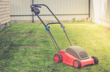 Yazlık bahçesinde çimenlerin üzerinde yeşil çim/biçme çimenlikte çim biçme makinesi