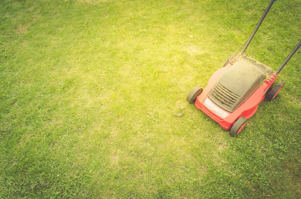 lawn mower on a green lawn/lawn mower on a green lawn. Top view and copyspace